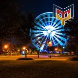 Fotografía nocturna de larga exposición de la Rueda Pepsi mientras se encontraba instalada dentro del parque fundidora de Monterrey.